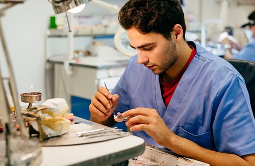 Lab technician customizing a permanent dental crown