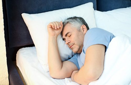 an older man resting in bed