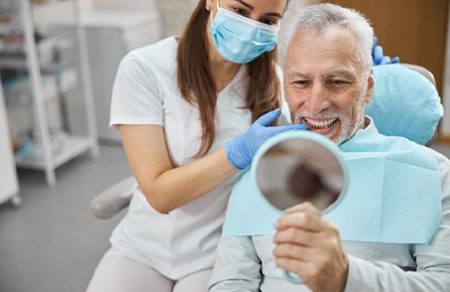 a patient checking his teeth with a mirror