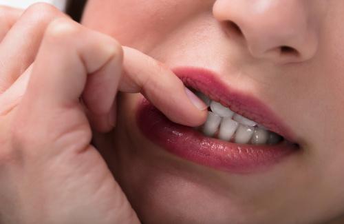 Closeup of woman biting her nails