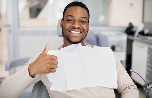 Smiling patient giving thumbs up in treatment chair